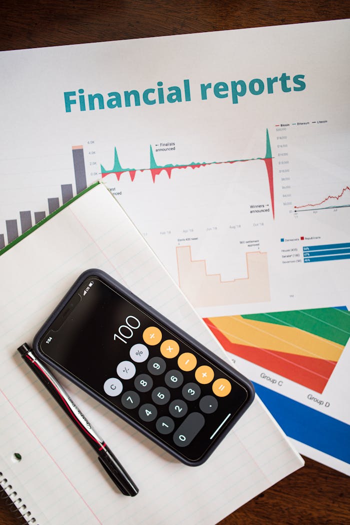 services-04 Top view of financial reports with a calculator app open on a smartphone.